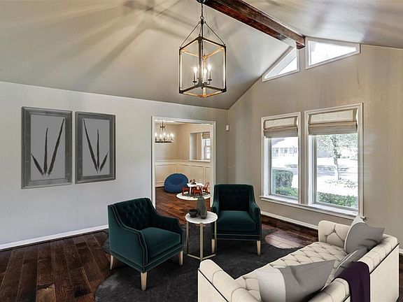 Light & bright formal Living offers cathedral ceiling with wood beam and custom chandelier