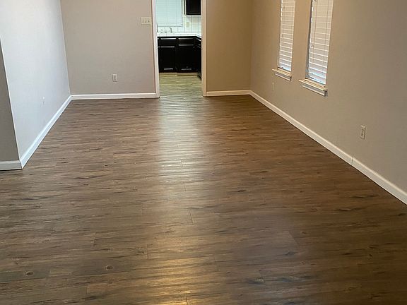 Formal dining area with vaulted ceiling flows into front living room. Doorway into kitchen.