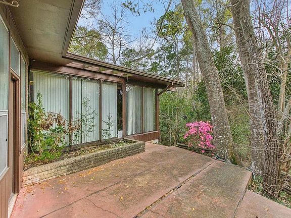 Walls of windows overlook a ravine with blooming azaleas.