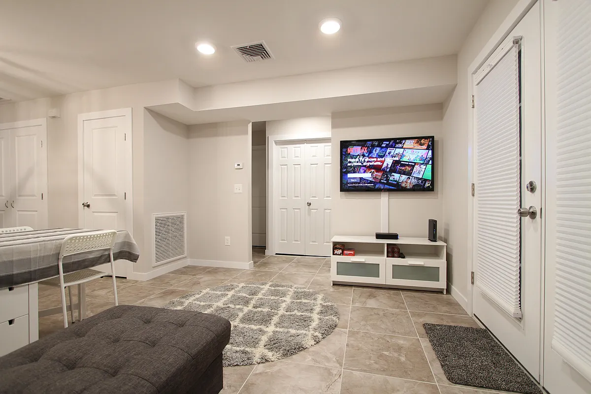 Spacious living room with entertainment setup and natural flow. - 13 Park St #1