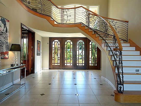 This is a look at the impressive matched set of custom double doors complemented by matching side units.  It also showcases a work of art posing as a custom designed, night-lit wrought iron staircase