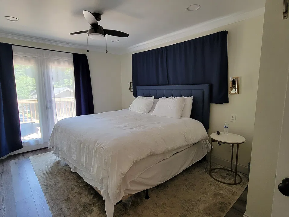primary bedroom, luxury King mattress next to french patio doors and facing a large television
