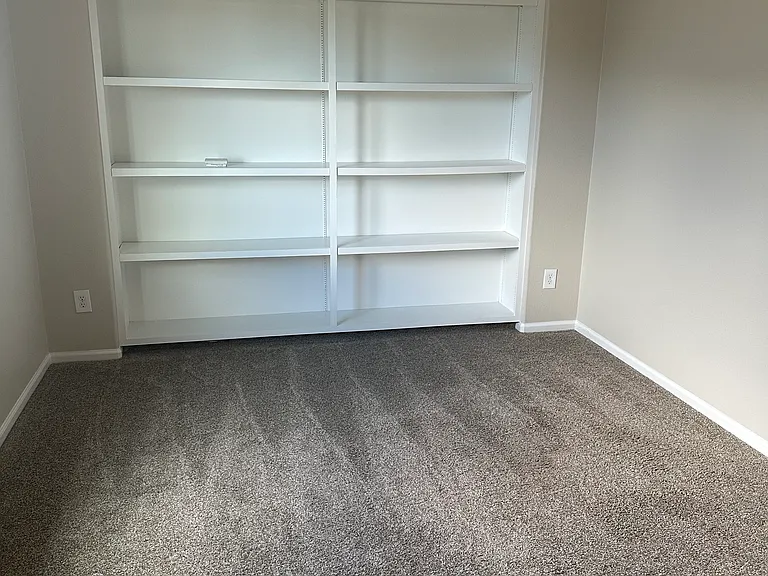 Upstairs loft area with built-in shelving.