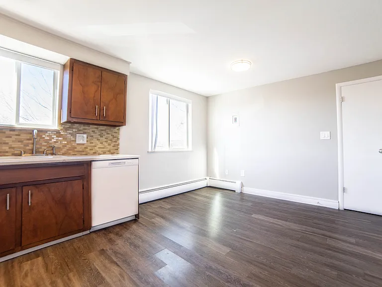 Inviting kitchen space featuring elegant wood cabinetry, sleek countertops, and ample sunlight through large windows.