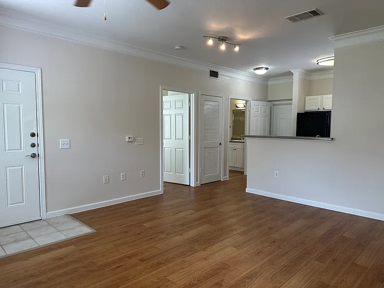 Bright and airy apartment interior with an open living area, modern kitchen, and elegant wood-style flooring. Bright and airy apartment interior with an open living area, modern kitchen, and elegant wood-style flooring.