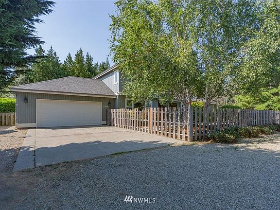 Two car attached garage has shelving and a door into the backyard.