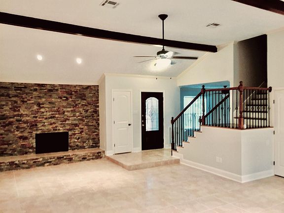 Living room with fireplace and vaulted ceiling.