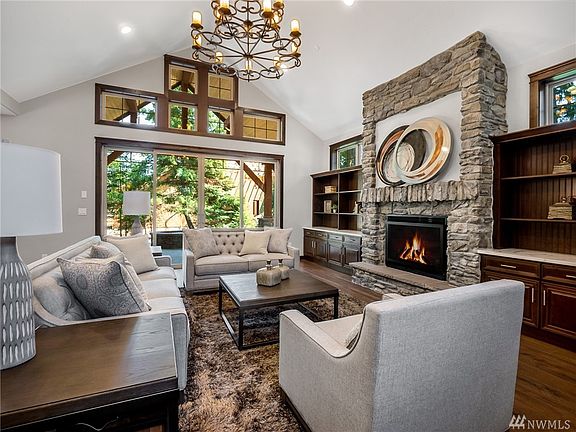 Thoughtful features of custom built in cabinets, a sitting area on the hearth, rich wooden trim and floors, in addition to the soaring 17' high architectural ceiling will make this great room one of your favorite areas to start or end your day. 