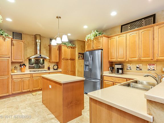 New SS appliances, corian counters, soft closing Kraftmaid maple raised panel cabinets w/lighting above/below & crown molding, large pantry closet w/ slide out drawers, stove w/ ss hood vented outside, recessed lights, open to large eat in area