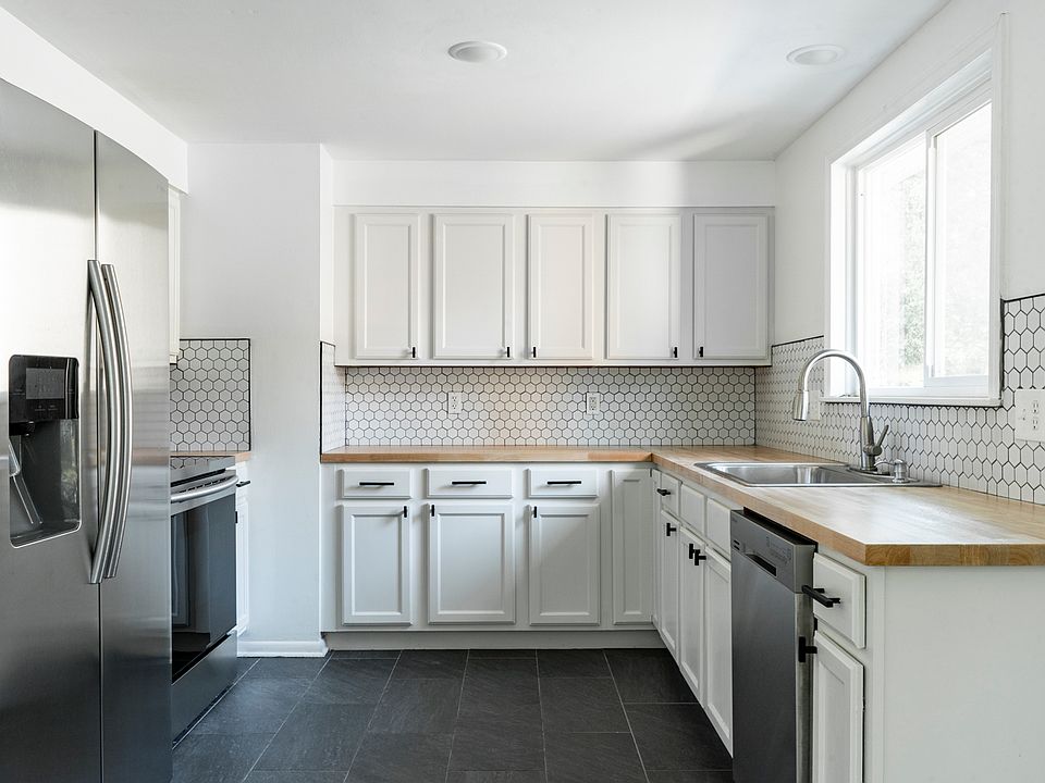 Updated kitchen with new butcher block countertops and backsplash.