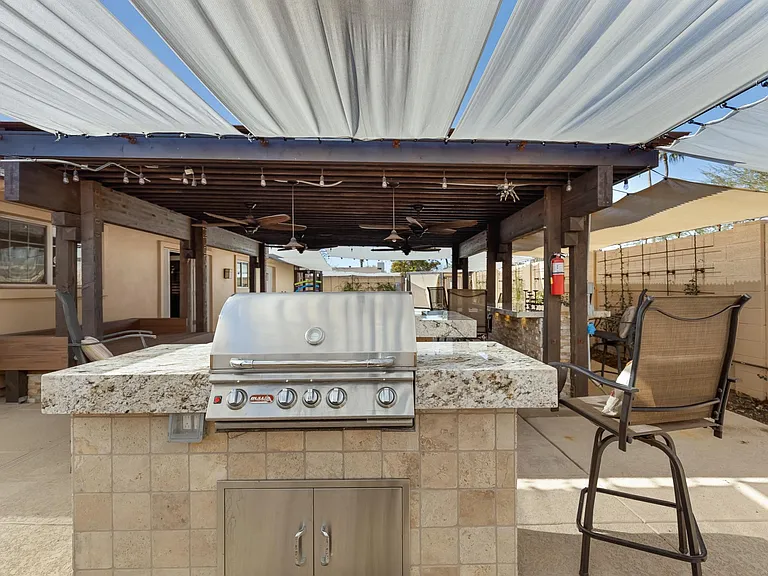 Gas grill is built in with a granite countertop.