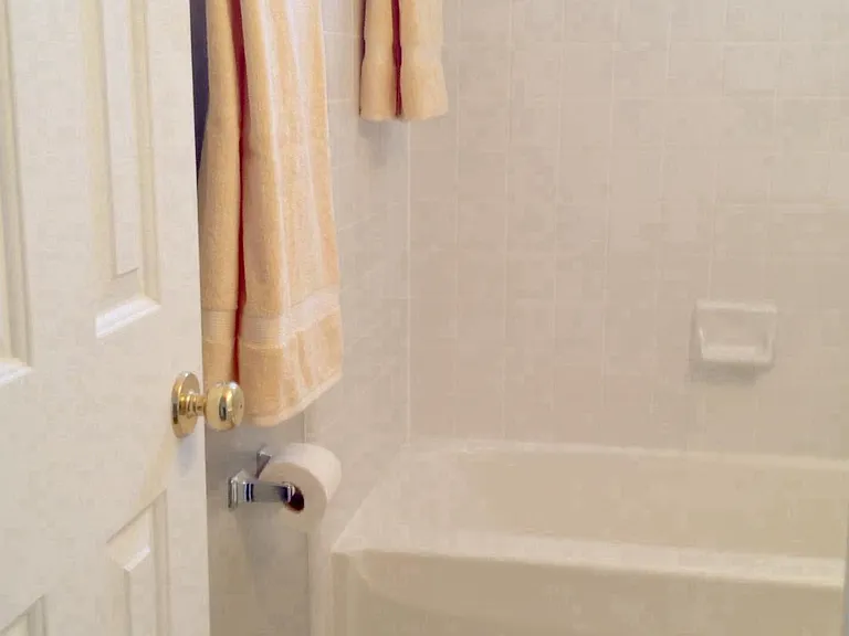 Hall full bath between bedrooms #2 and #3. Shower in tub. Dbl. towel bar, shelf above (not pictured), plus third towel bar. Newly tiled floor has large slate gray tiles. Easy clean!
