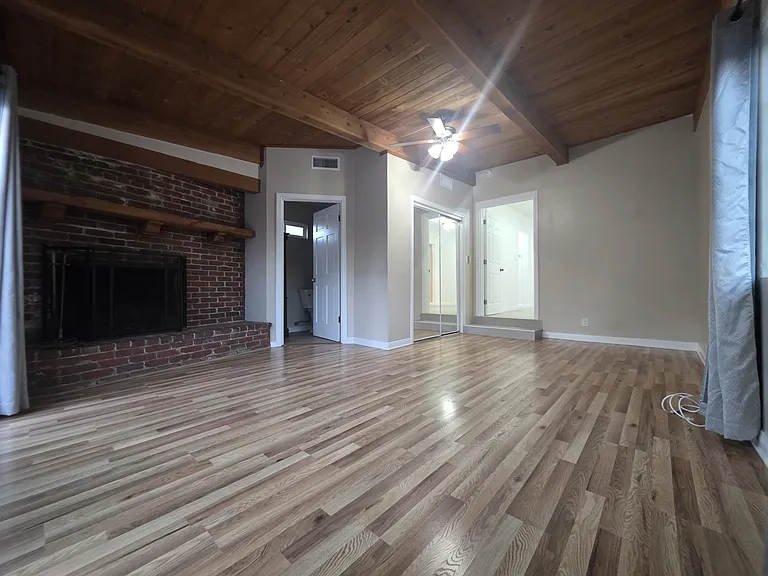 Master bedroom with chimney, mirror closet doors, large window and sliding door