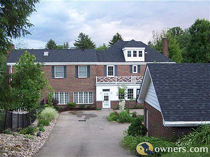 Back of house with circular driveway and 3 car garage