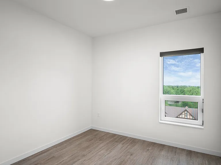 Bright and airy room with large window and hardwood floor, offering a serene view of lush greenery. Bright and airy room with large window and hardwood floor, offering a serene view of lush greenery.