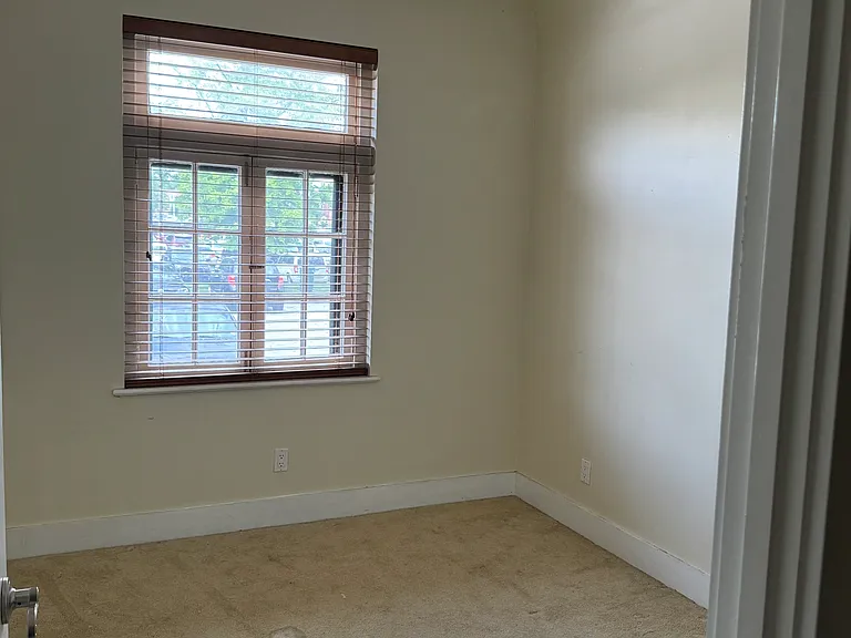 Second bedroom with carpet floor and large window.