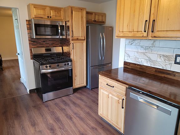 Kitchen with new gas range, over-range microwave, and dishwasher.