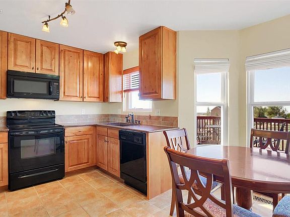 Upgraded kitchen with tall knotty alder cabinetry, designer hardware, granite co