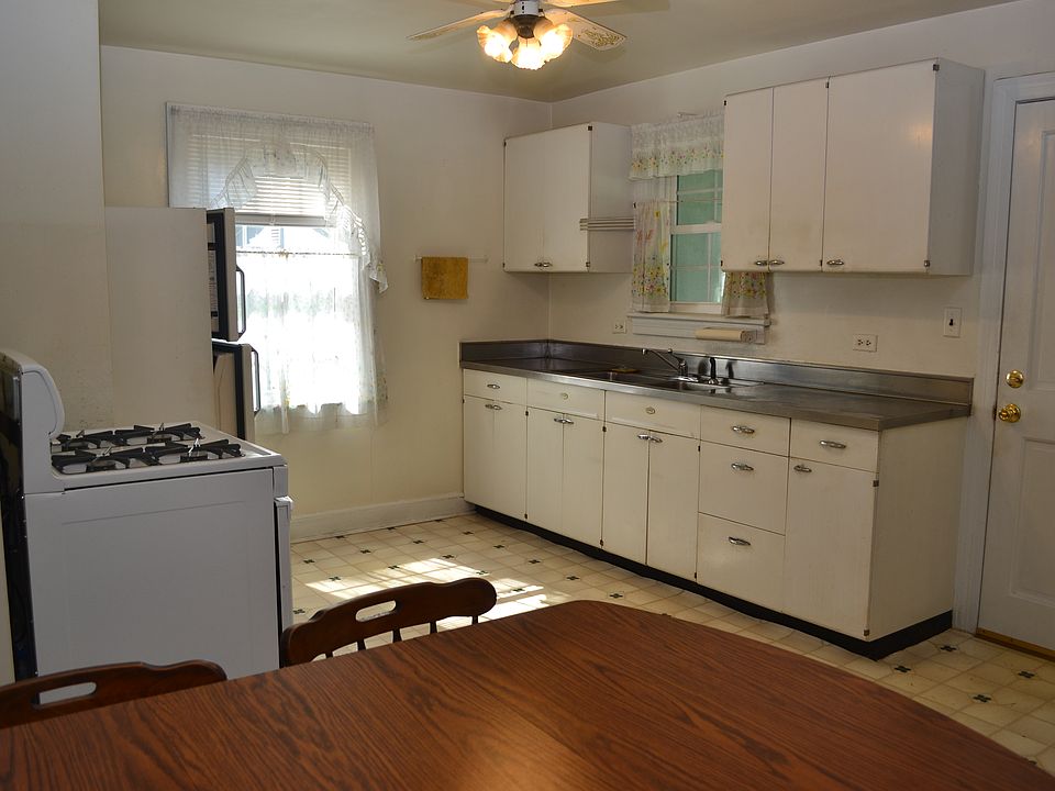Kitchen with classic stainless steel counter and sink. Propane gas range. 