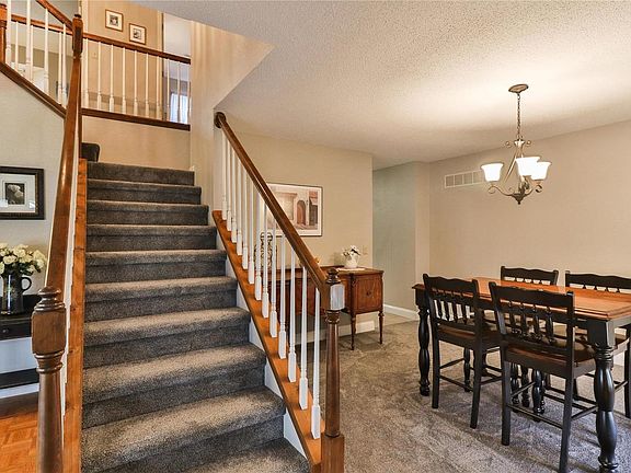 The t-staircase shares the open space with the living room to the left and formal dining room to the right.