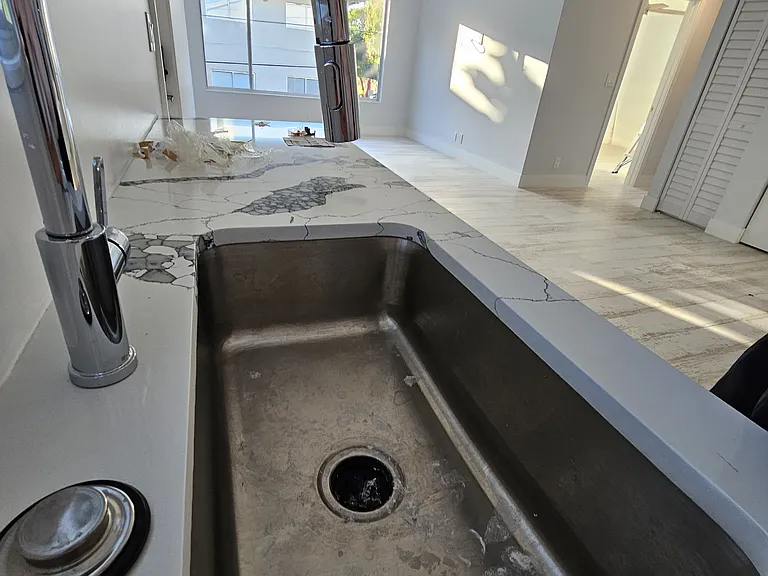 Under counter mounted stainless steel kitchen sink.