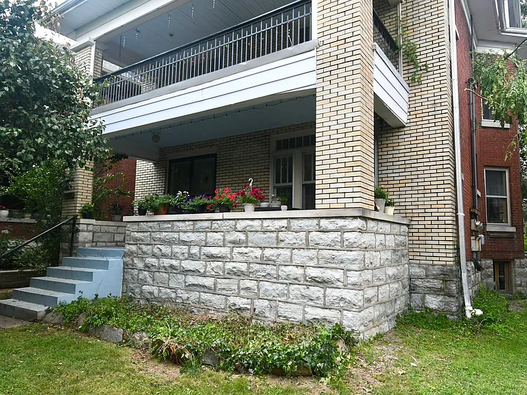 2nd floor balcony overlooks trees and street front