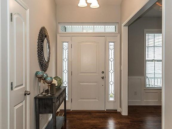 Foyer with vaulted ceilings, wood floor, and coat closet.