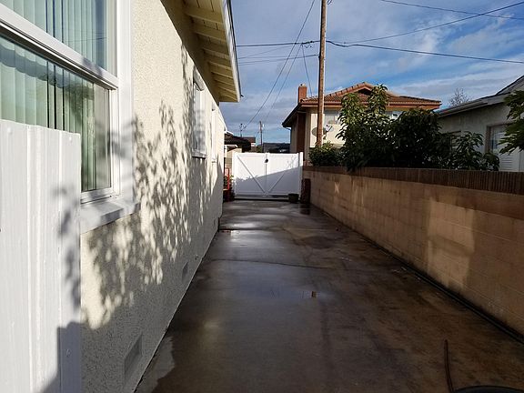 Behind the double door gates there is a 9.5 wide concreted area/drive going into the backyard. Brick walls.
