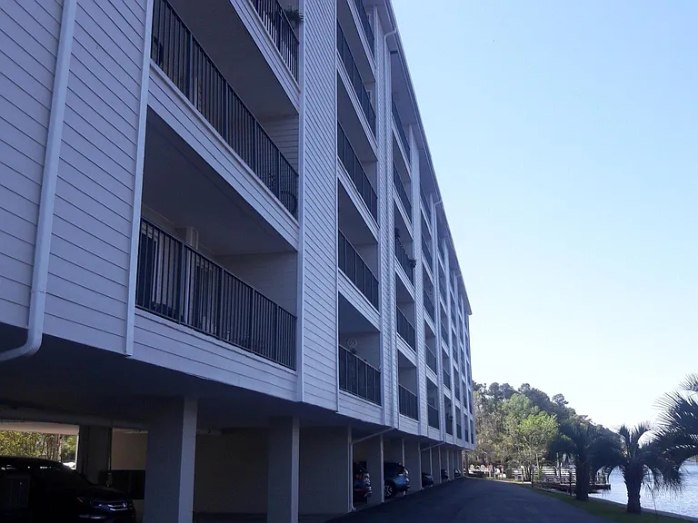 Waterway back of building and parking for 1 vehicle per unit under building. Extra vehicle parking in front lot.