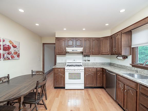 Plenty of cabinets in this eat in kitchen along with recessed lighting.