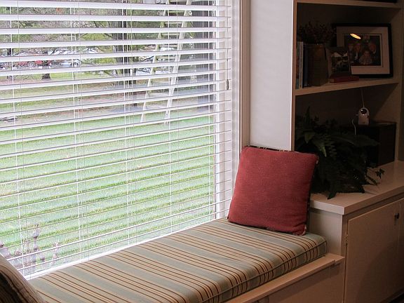 charming window seat in between built in bookshelves and cabinets