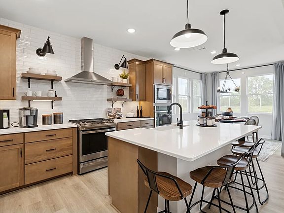 Kitchen with pendant lighting and subtle wood stained cabinets