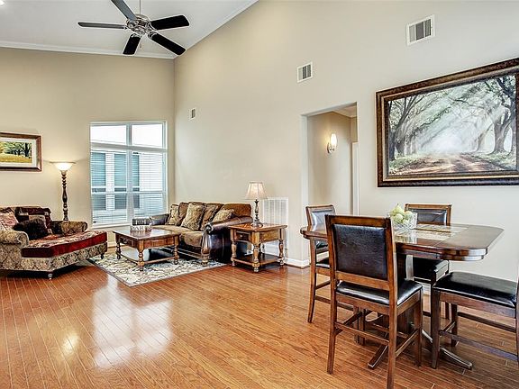 Second floor living area is open, bright and spacious with a high ceiling and gleaming wood floors.