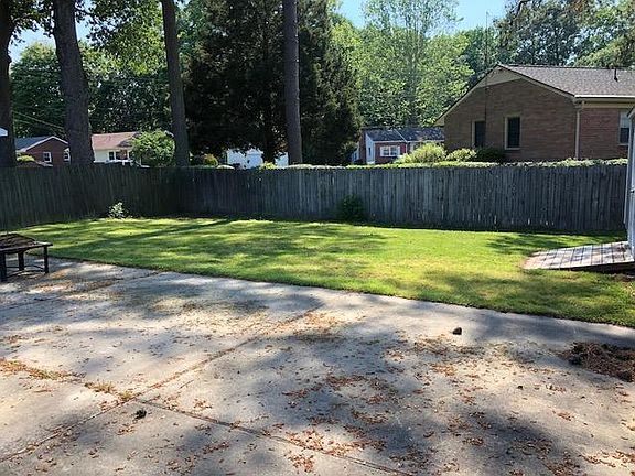 Fenced in backyard with storage shed and table