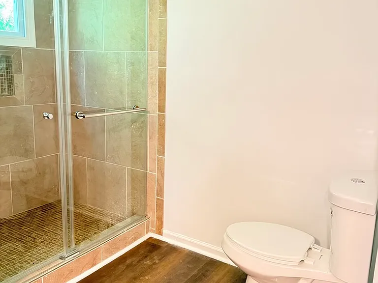 Renovated tiled walk-in shower and new push toilet , flloring in Master Bathroom.