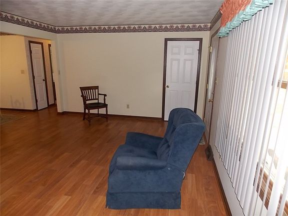 Second angle of living room with view of coat closet.  There are also two linen closets and a double wide closet with rod in hallway.