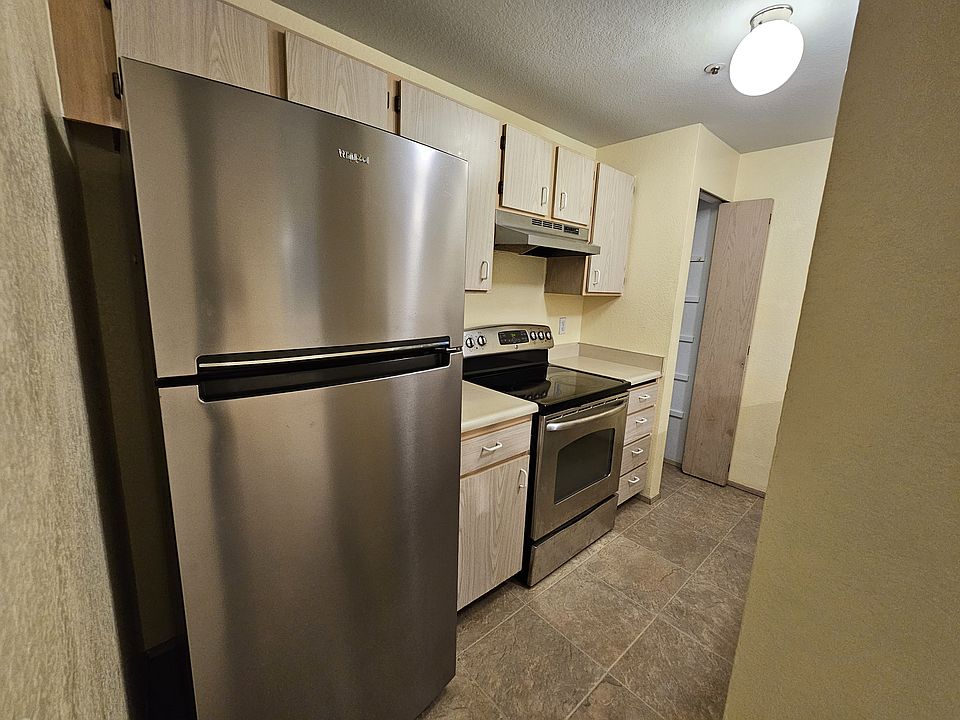 Kitchen view on fridge, range stove, pantry and storage cabinets