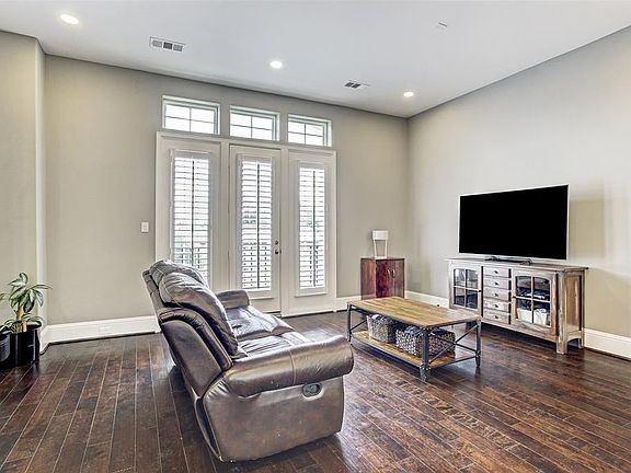 The spacious living area features French doors leading to a balcony, and ornamental windows adding lots of natural light.