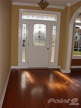 Wide foyer with beautiful hardwood flooring.