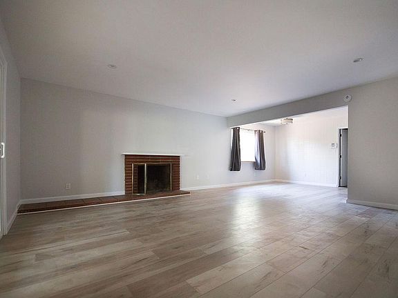 Open space living area. Left is sliding door towards enclosed patio. Right top corner is dining area