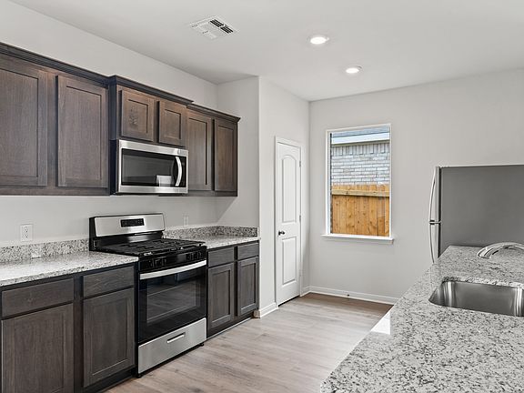 The kitchen has gorgeous wood cabinetry.