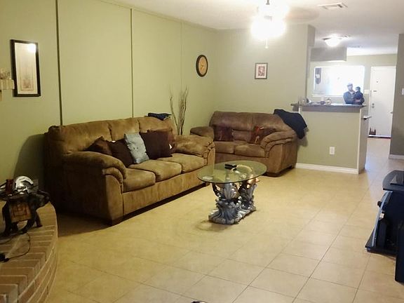 SPACIOUS FAMILY ROOM WITH A FIREPLACE AND TILE FLOORS THAT OVERLOOKS KID'S PLAYROOM, KITCHEN, AND BEDROOMS.