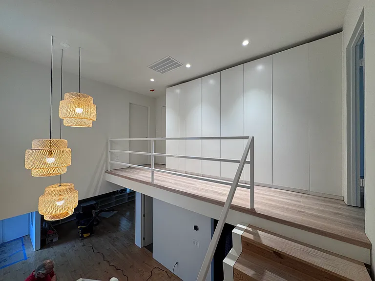 Bright upper landing with floor-to-ceiling storage and modern pendant lighting.