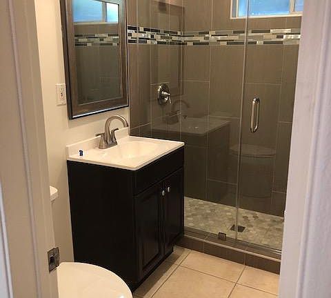 New stand up shower, fixtures, vanity, and toilet.