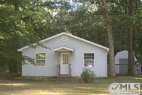 Front view of home with storage shed in backyard
