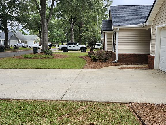 View of the front yard taken from the right side of the property. Photo reveals a glimpse of the quiet neighborhood.