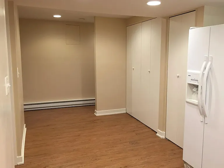 View from the kitchen area looking into the laundry space and towards the entrance stairwell.