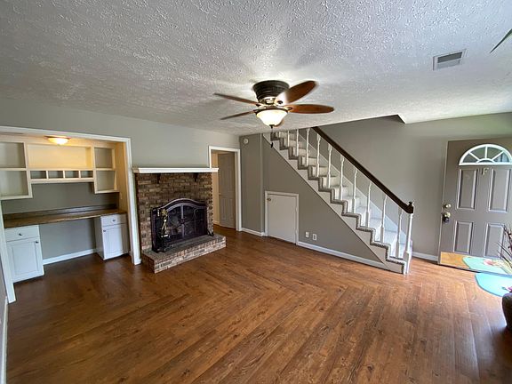 Beautiful hardwoods in livingRoom with fireplace and office area