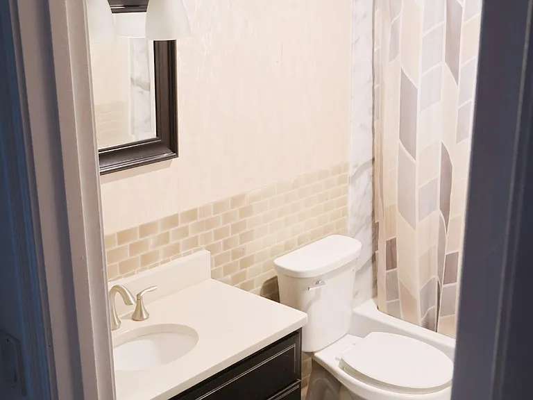Bathroom _ Fully Renovated Within the Past Year, Featuring a New Tub, Toilet, Sink, Flooring, Wallpaper, and Cabinetry.