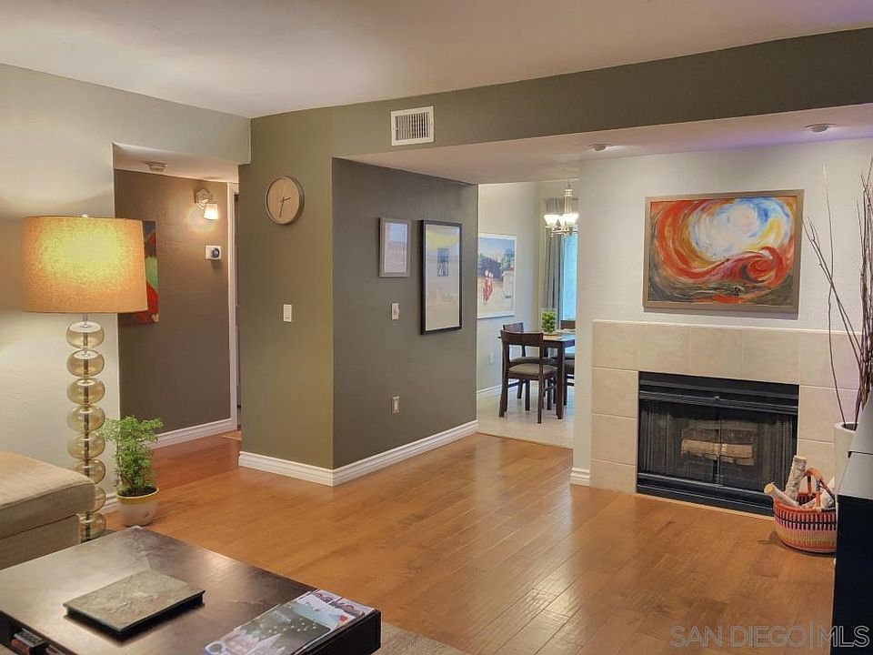 Engineered wood flooring, fireplace with accent lighting.